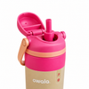 A close-up of an Owala water bottle with a bright pink flip-top lid and straw, a peach carrying loop, and a beige lower body on a white background.