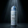 An Owala water bottle with a light blue flip-top lid and a white body decorated with light blue ribbon illustrations, set against a dark background with dramatic spotlight rays.