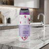An Owala insulated water bottle with a purple lid and cartoon character graphics, standing on a white marble kitchen countertop with a blurred kitchen background.