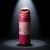 A pink Owala insulated water bottle with a floral pattern, standing upright on a dark surface under a spotlight.