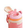 A close-up of a pink Owala water bottle with a flip-top lid, translucent pink straw, and orange accent band, shown on a white background.