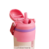 A close-up of a pink Owala water bottle lid with the straw open and hinged, showing a purple band and a beige bottle body on a white background.