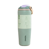 A Owala insulated tumbler in sage green with a light green paper band label, a lavender flip-top lid, and a beige carrying loop, shown on a solid white background.